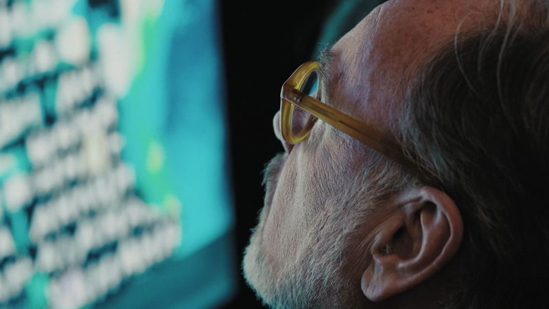 Nahaufnahme eines Besuchers mit Brille vor einer Arbeit