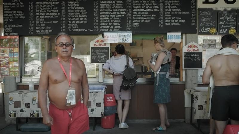 Ein Badegast mit roter Badehose vor dem Buffet