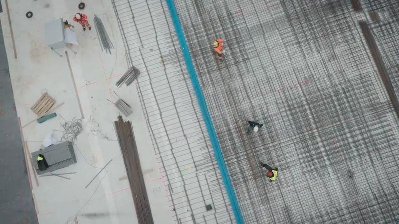 Die Baustelle von oben, Arbeiter auf dem Bewehrungsgitter