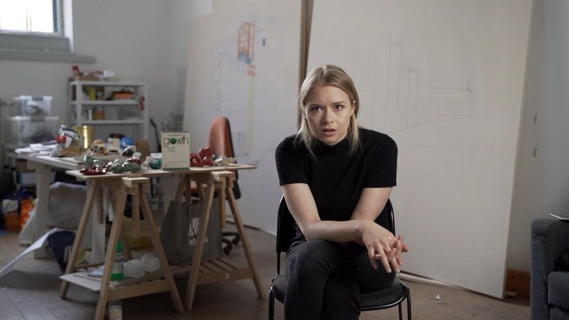 Mette Riise sitzt im Atelier und blickt in die Kamera